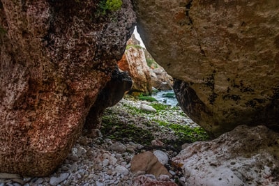 Beside the waters near the cave of the rocks on the ground
